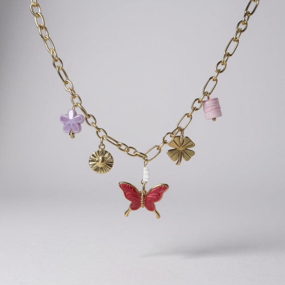 Collier papillon rouge et breloques sur chaîne dorée